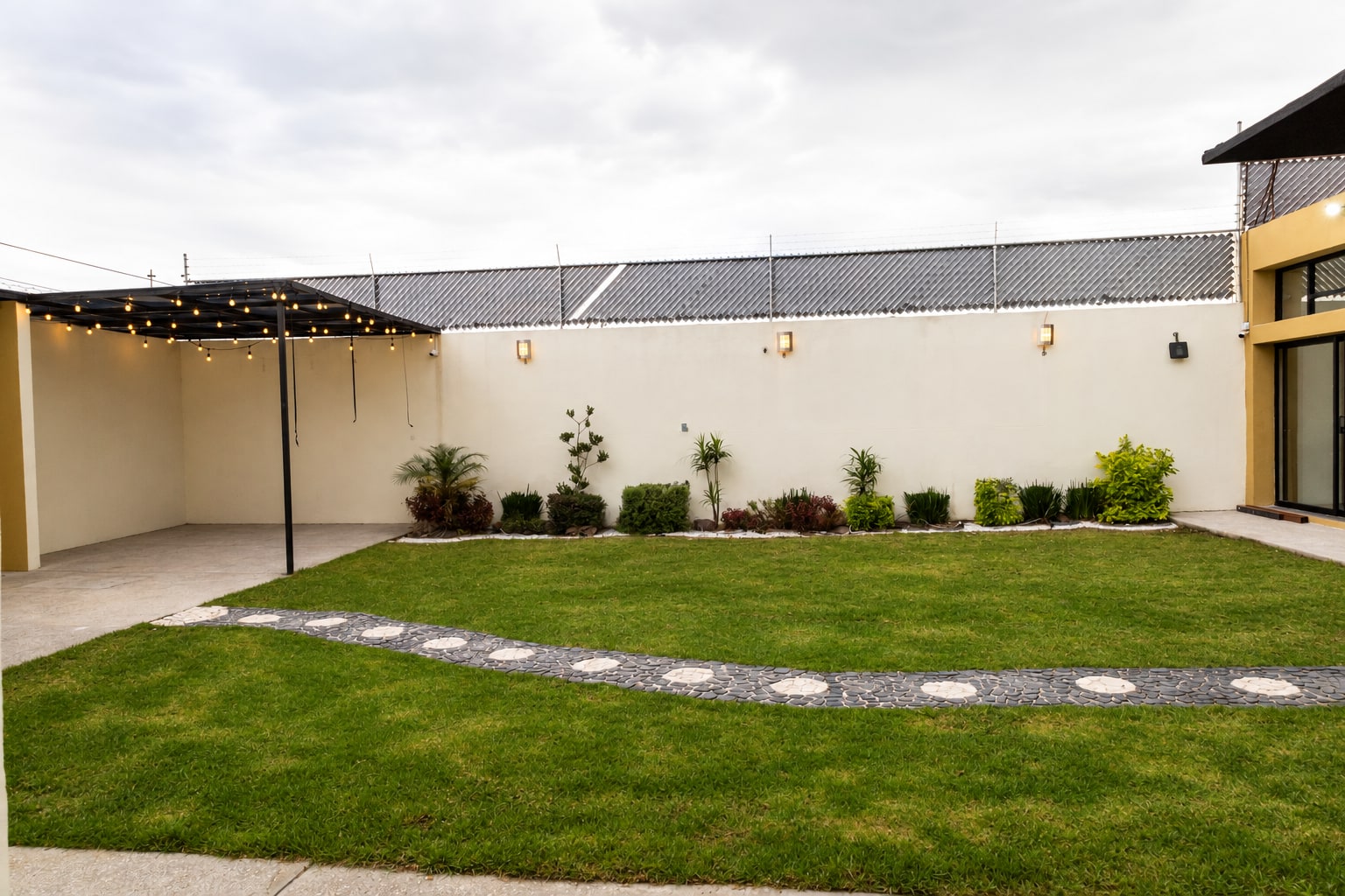 Jardín de Yalduna en Cuautlancingo, con césped, plantas y área techada